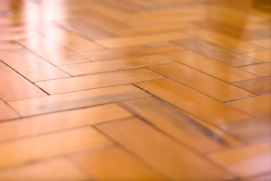 Glossy herringbone floor catching warm light