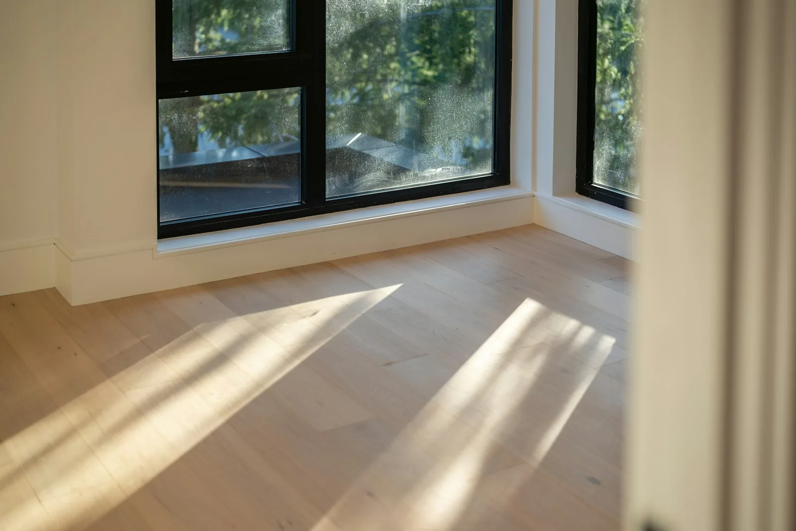 Long window shadows falling across pale wood planks