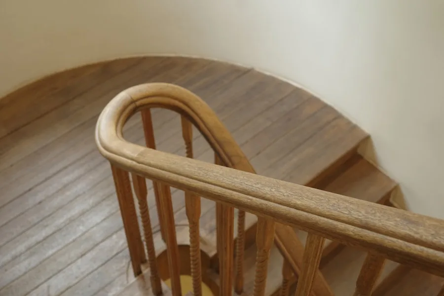 Curved wooden handrail turning at the top of a staircase