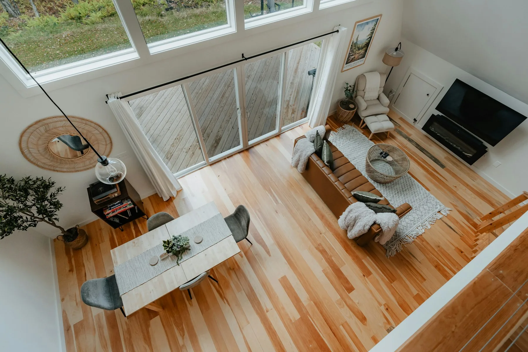 Open living and dining room seen from above, light oak floor throughout