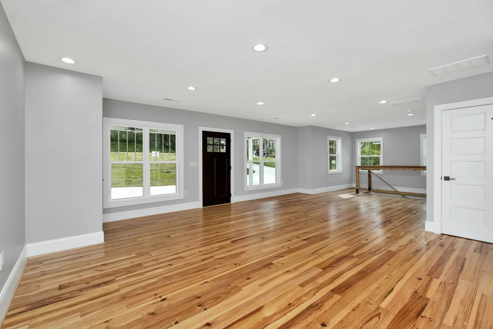 Empty room with a wide plank oak floor and afternoon light